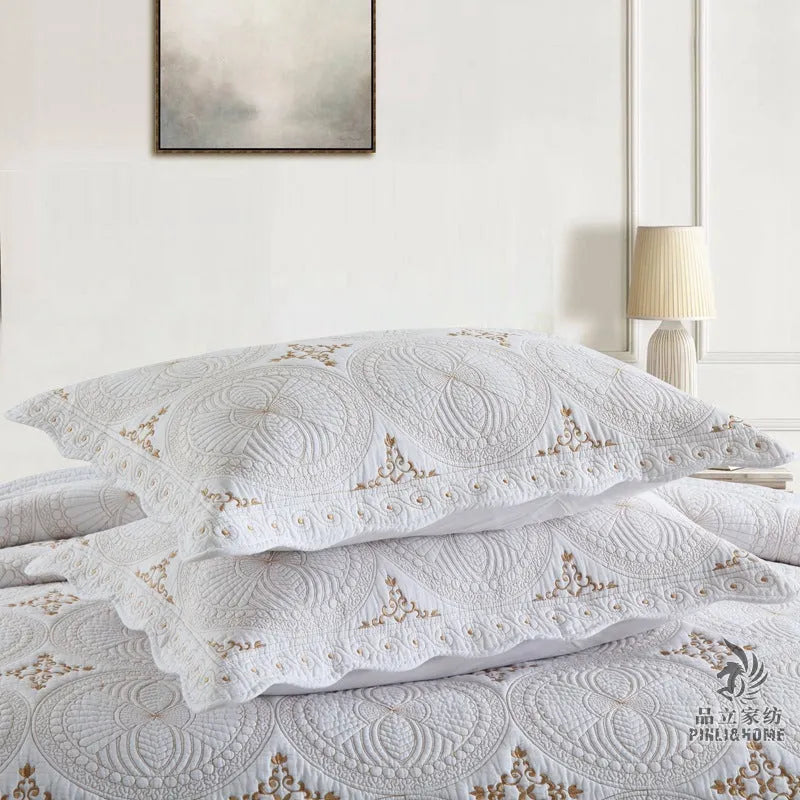 Double thick pure cotton European-style embroidered bed cover set with two pillowcases on a bed.