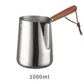 Stainless steel milk frothing jug with volume scale and wooden handle in three size options.