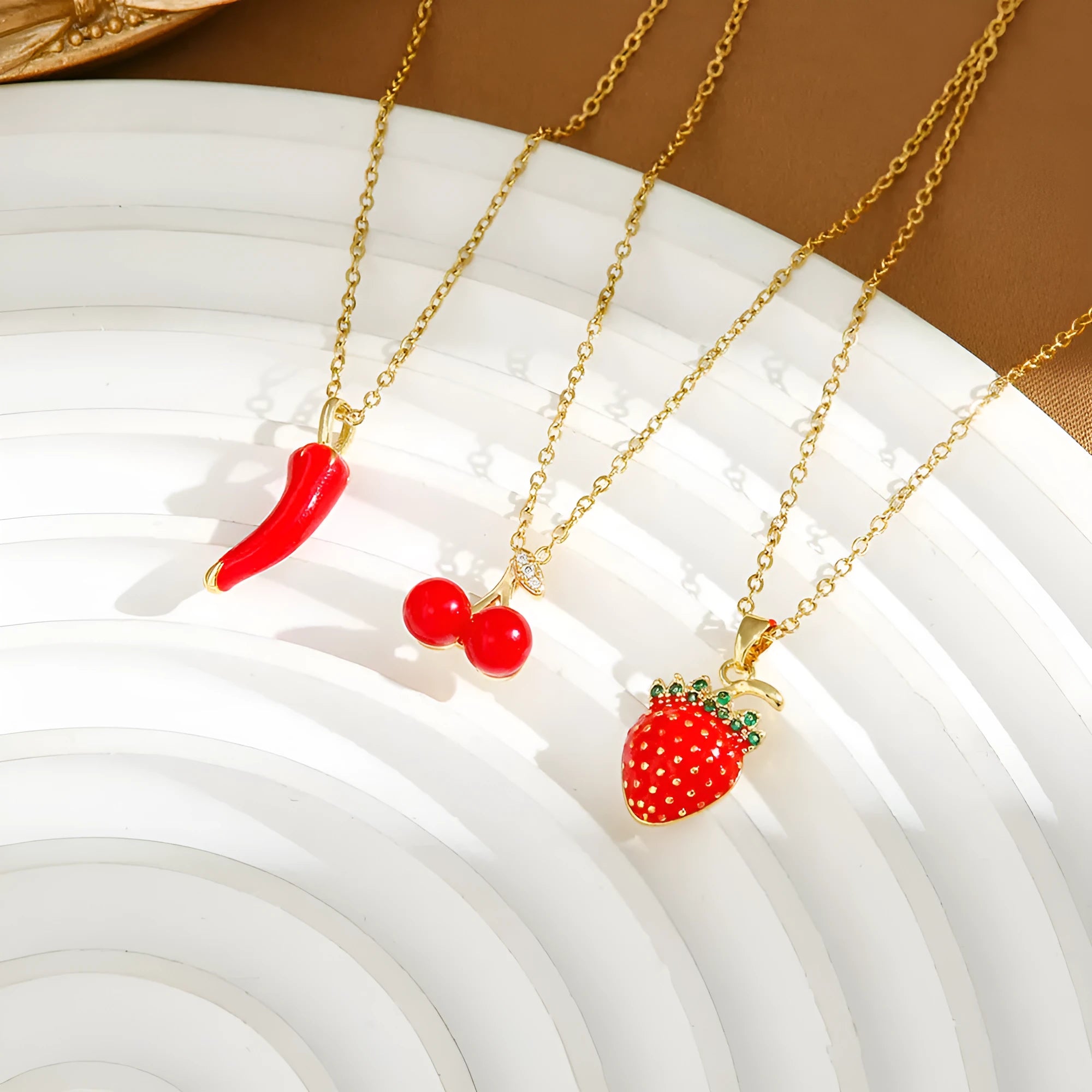 Women's titanium steel necklace with O-ring chain showing cherry, strawberry, and pepper charm options.