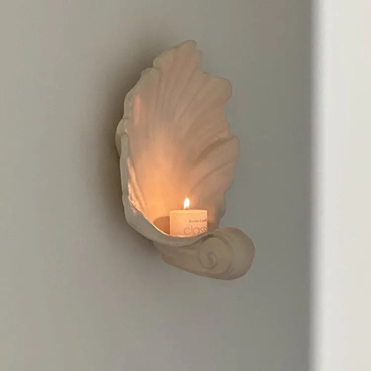 White resin shell-shaped fruit plate ornament on a table.