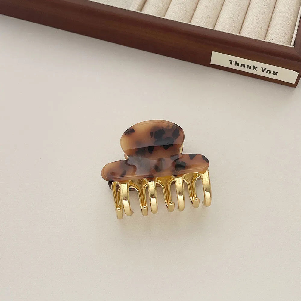 Set of four retro acetate hair barrettes with metal grip in beige, white, dark, and leopard print designs
