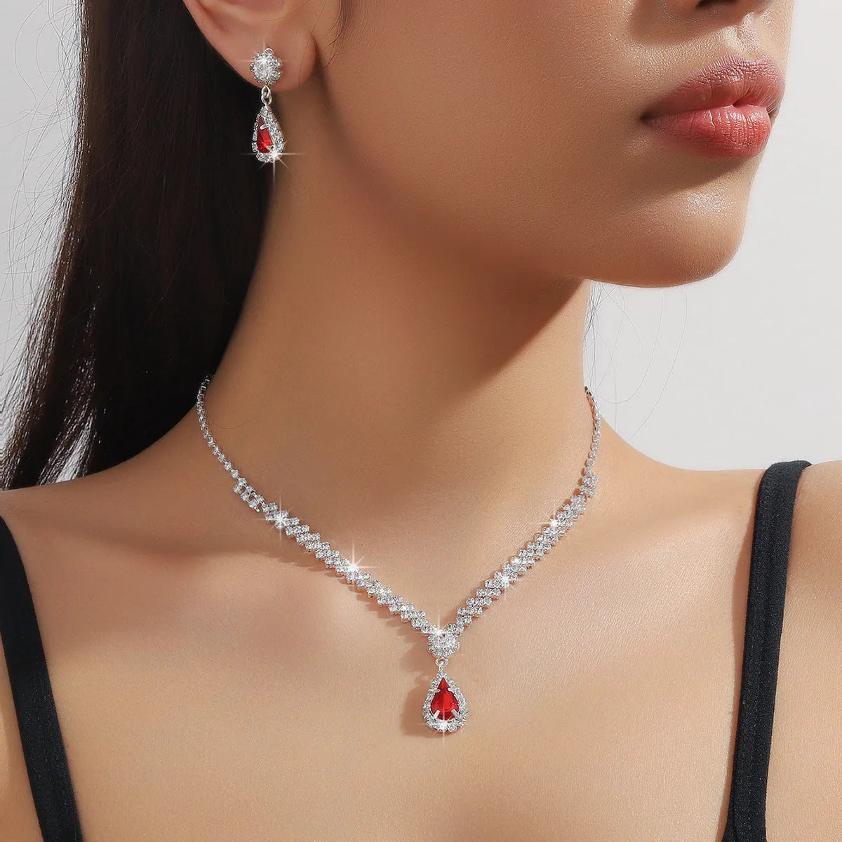 Women's blue claw chain necklace and drop rhinestone earrings from a matching jewellery set.