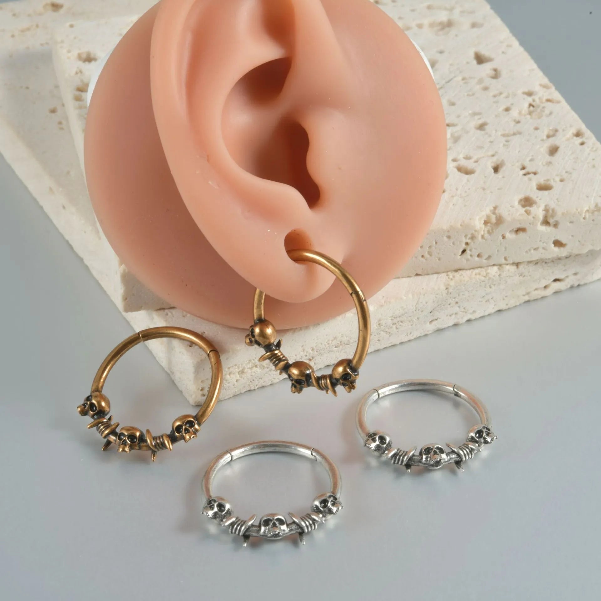 Close-up of copper punk earring with detailed ghost head design in antique silver finish.