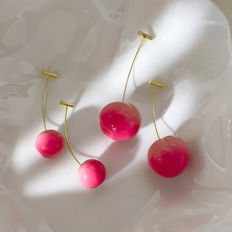 A pair of acrylic peach-shaped earrings with copper fittings, shown in small and large size options.