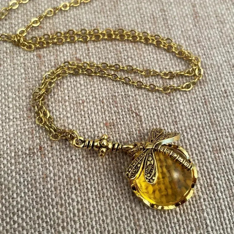Vintage bronze hand carved dragonfly pendant on a silver chain, yellow colour