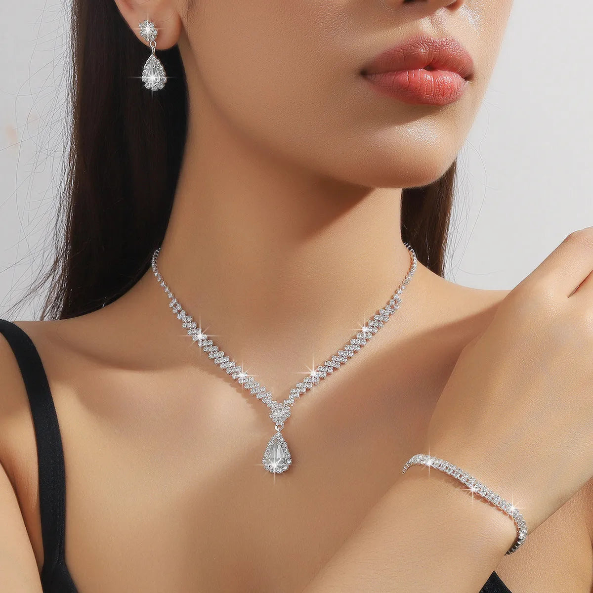 Women's blue claw chain necklace and drop rhinestone earrings from a matching jewellery set.