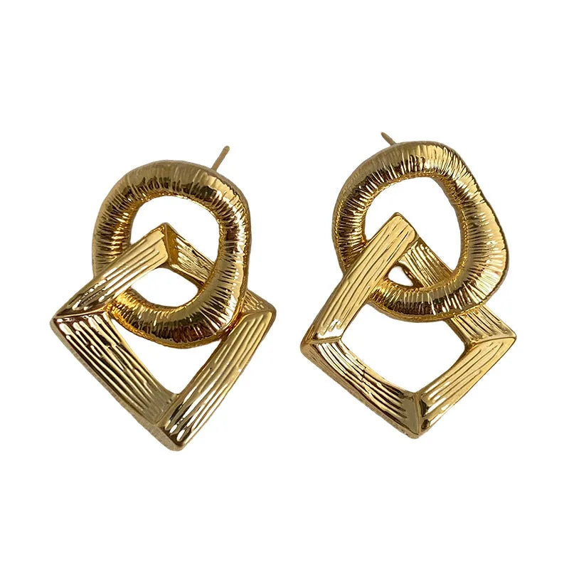 Retro geometric circle pendant earrings in gold or silver tone on a white background.