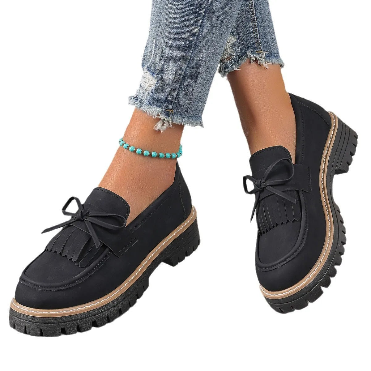 Plus size women's black loafers with a tassel and bow knot detail on the upper.