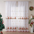 Pair of white Christmas curtains with embroidered red and green snowflake design, hung on a window.