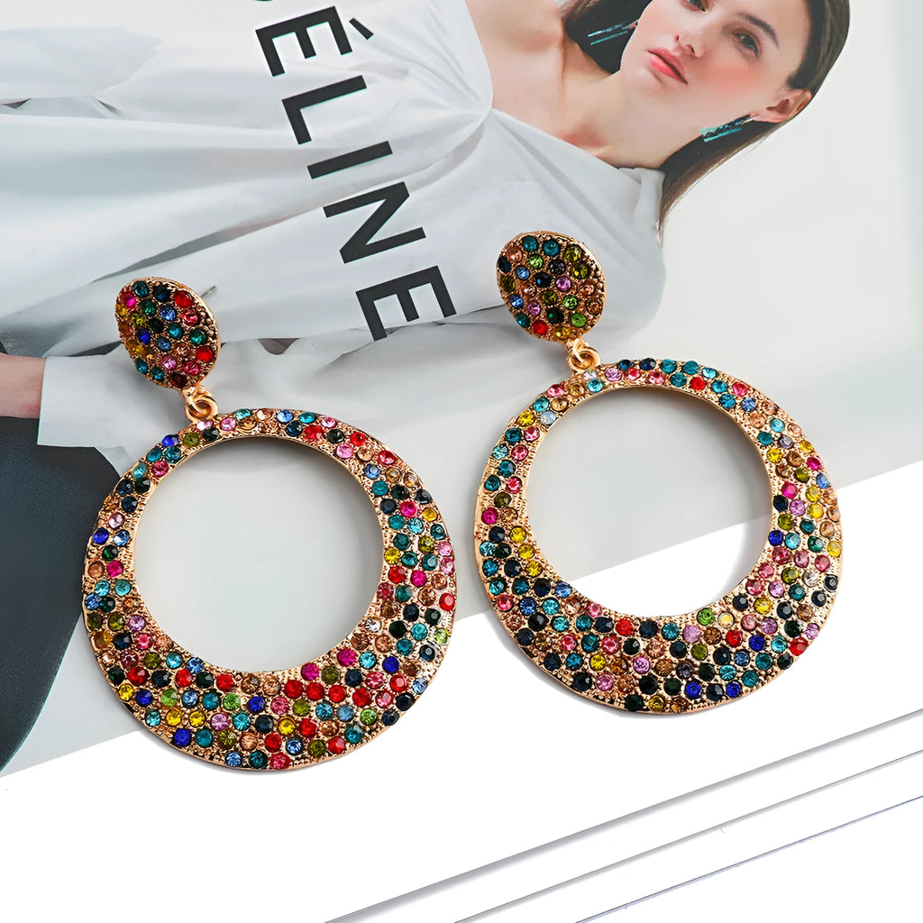 A pair of large colourful round pendant drop earrings with a cartoon style, made from metal alloy.