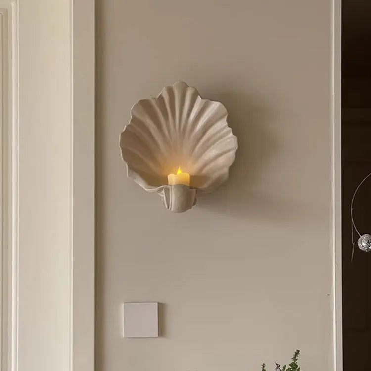 White resin shell-shaped fruit plate ornament on a table.