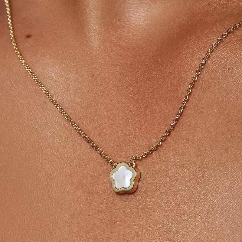 White mother-of-pearl shell flower necklace on a chain in silver or gold tone.