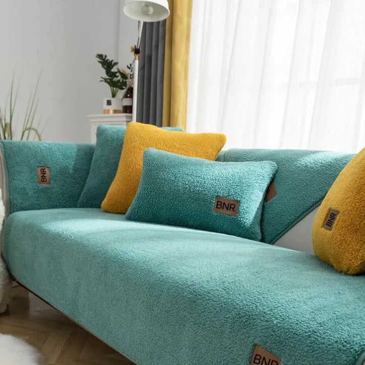 Lambswool machine-washable sofa cover in solid blue colour on a grey sofa