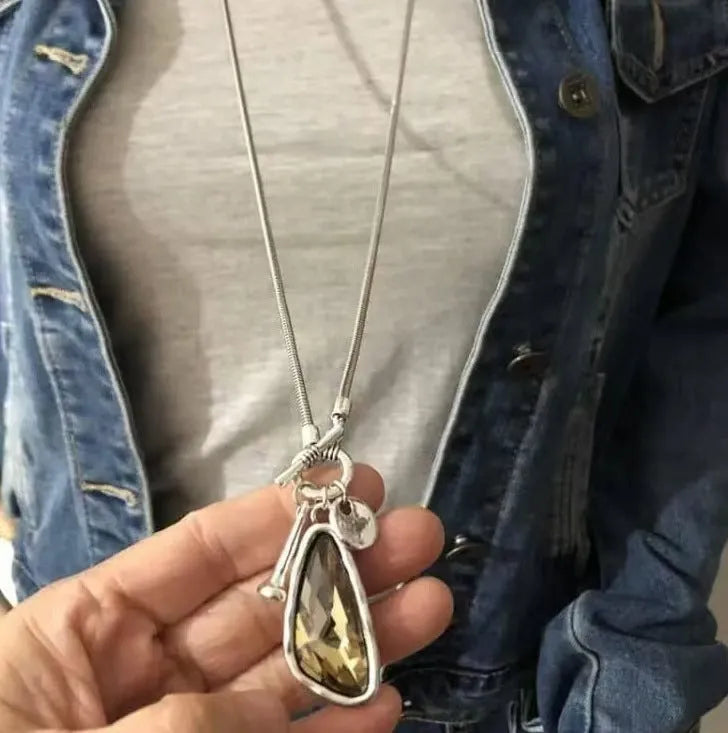 Long alloy sweater chain necklace with a geometric plaid pendant on a snake bones chain.
