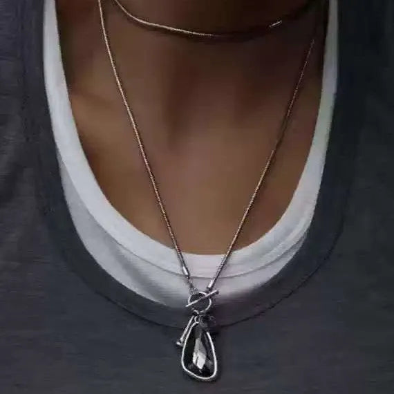 Long alloy sweater chain necklace with a geometric plaid pendant on a snake bones chain.