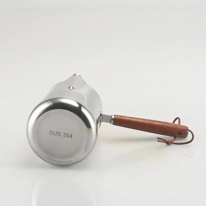 Stainless steel milk frothing jug with volume scale and wooden handle in three size options.