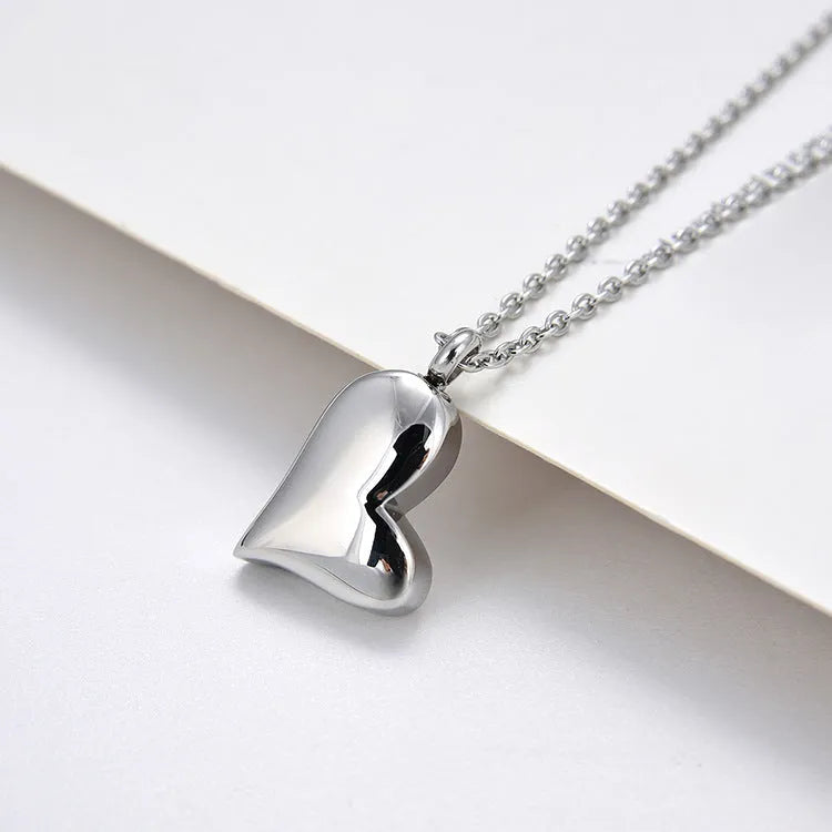 Silver stainless steel curved peach heart pendant necklace on a chain with extension