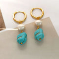 A pair of women's geometric drop earrings with irregular turquoise stones and round cultured pearls on copper settings.