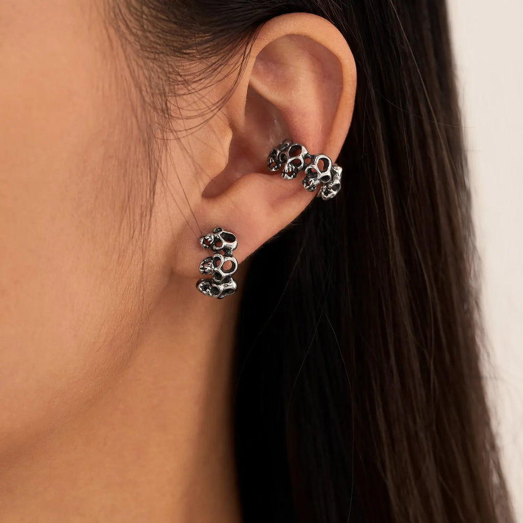 Stainless steel skull clip earrings with geometric hollow design and metallic finish