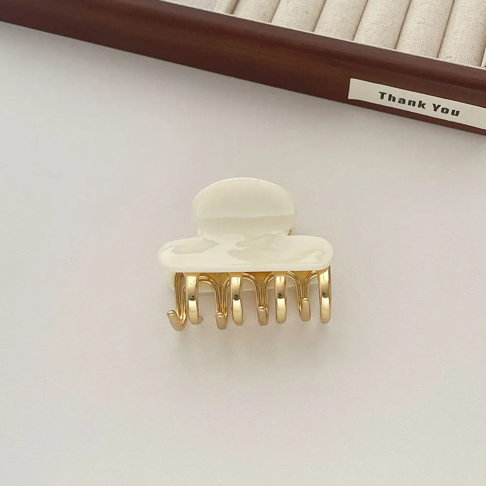 Set of four retro acetate hair barrettes with metal grip in beige, white, dark, and leopard print designs