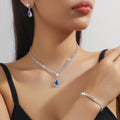 Women's blue claw chain necklace and drop rhinestone earrings from a matching jewellery set.
