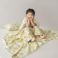 Anti-kick sleeping bag blanket in a summer design on a bed, showing its lightweight texture.