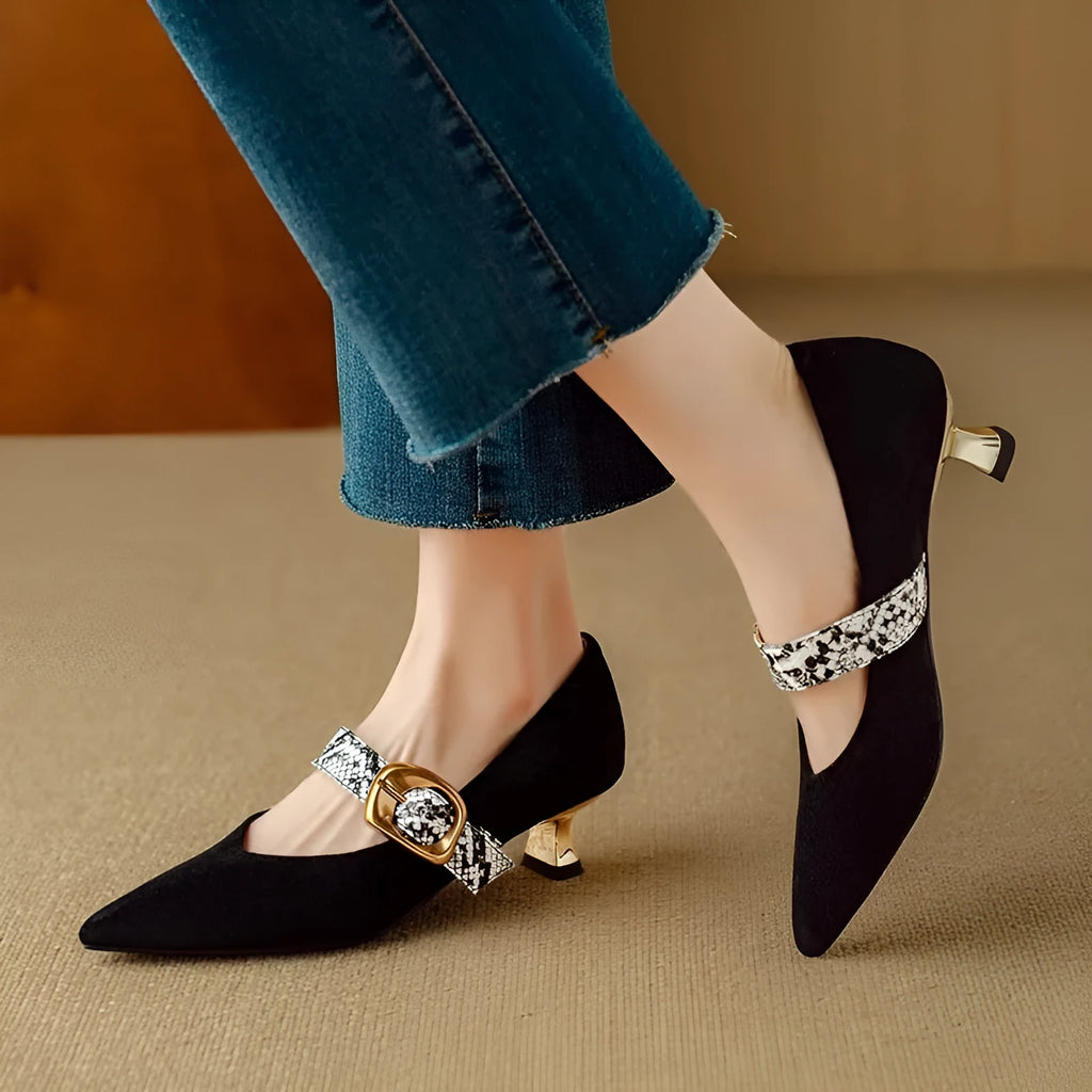 Women's black pointed toe stiletto heels with a buckle strap and a mid-height heel.