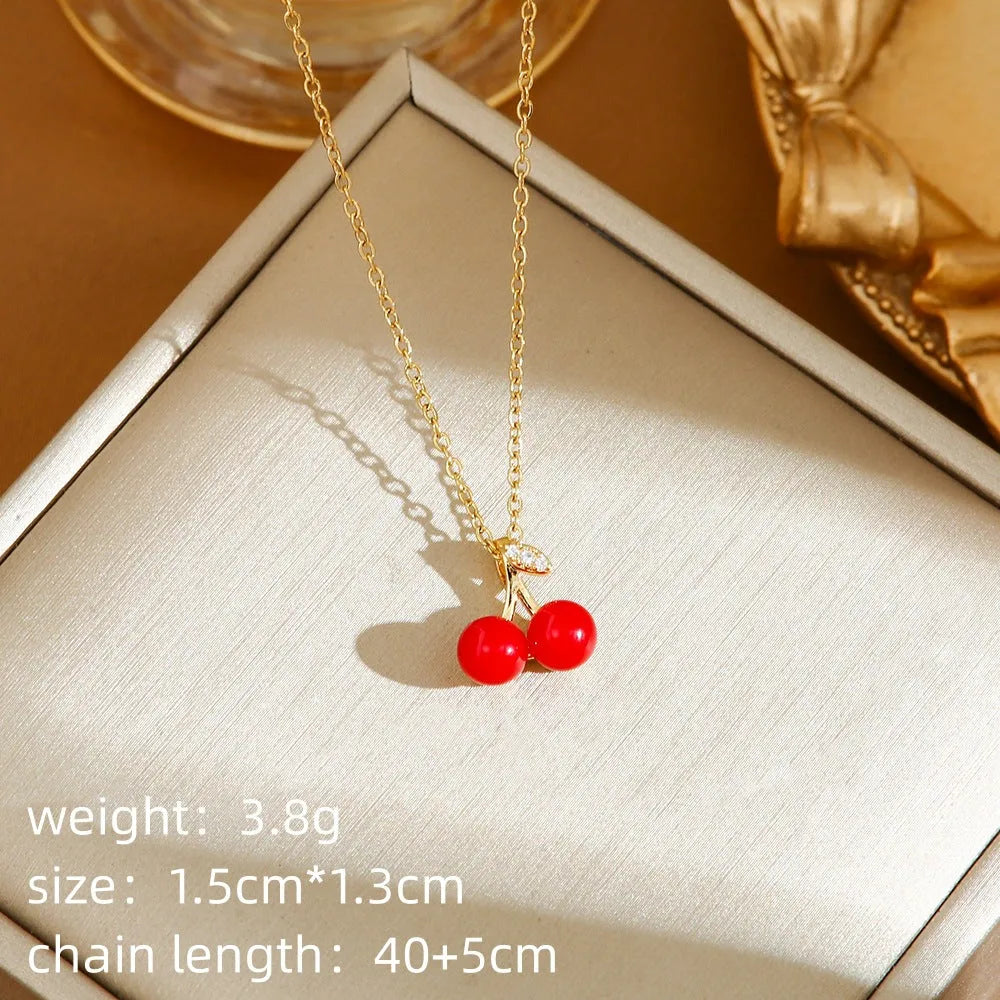 Women's titanium steel necklace with O-ring chain showing cherry, strawberry, and pepper charm options.