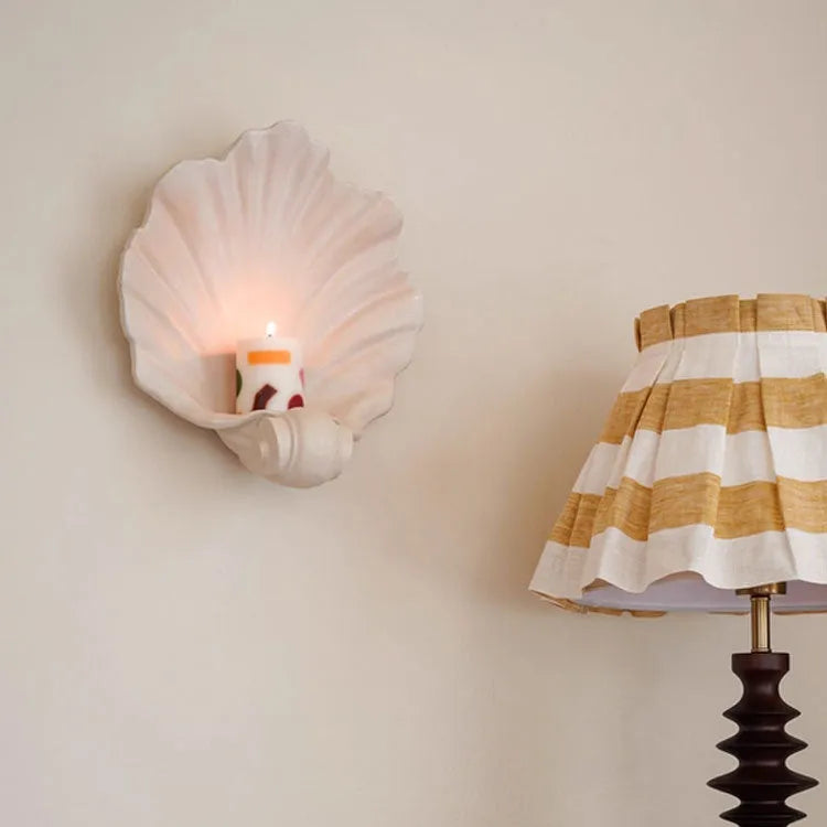 White resin shell-shaped fruit plate ornament on a table.