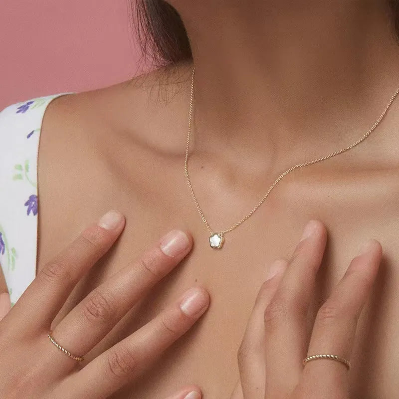 White mother-of-pearl shell flower necklace on a chain in silver or gold tone.