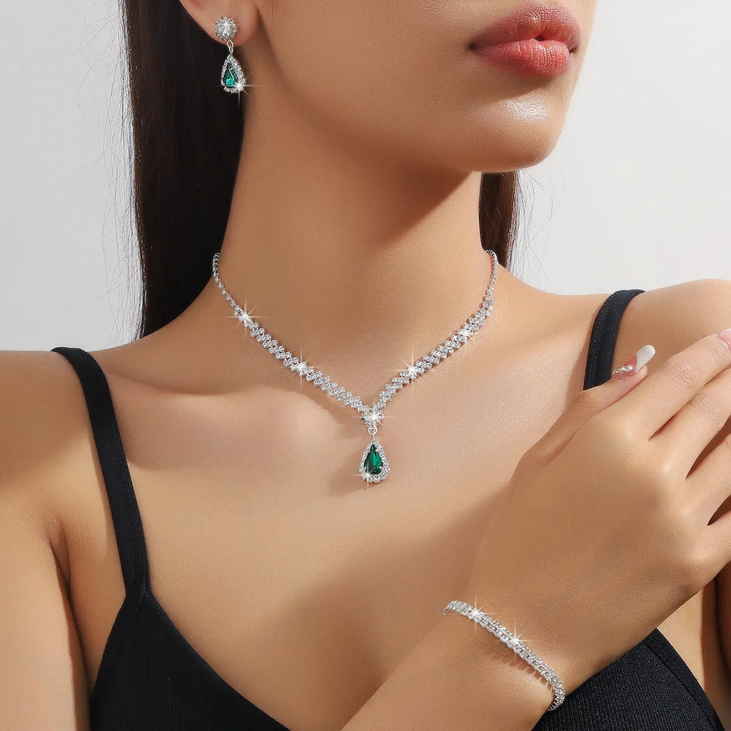 Women's blue claw chain necklace and drop rhinestone earrings from a matching jewellery set.