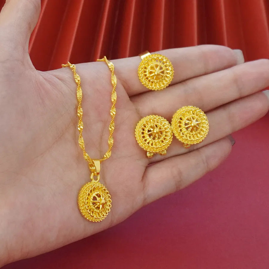 Gold-plated three-piece jewellery suit with landscape Middle East flower designs showing earrings, ring and pendant necklace