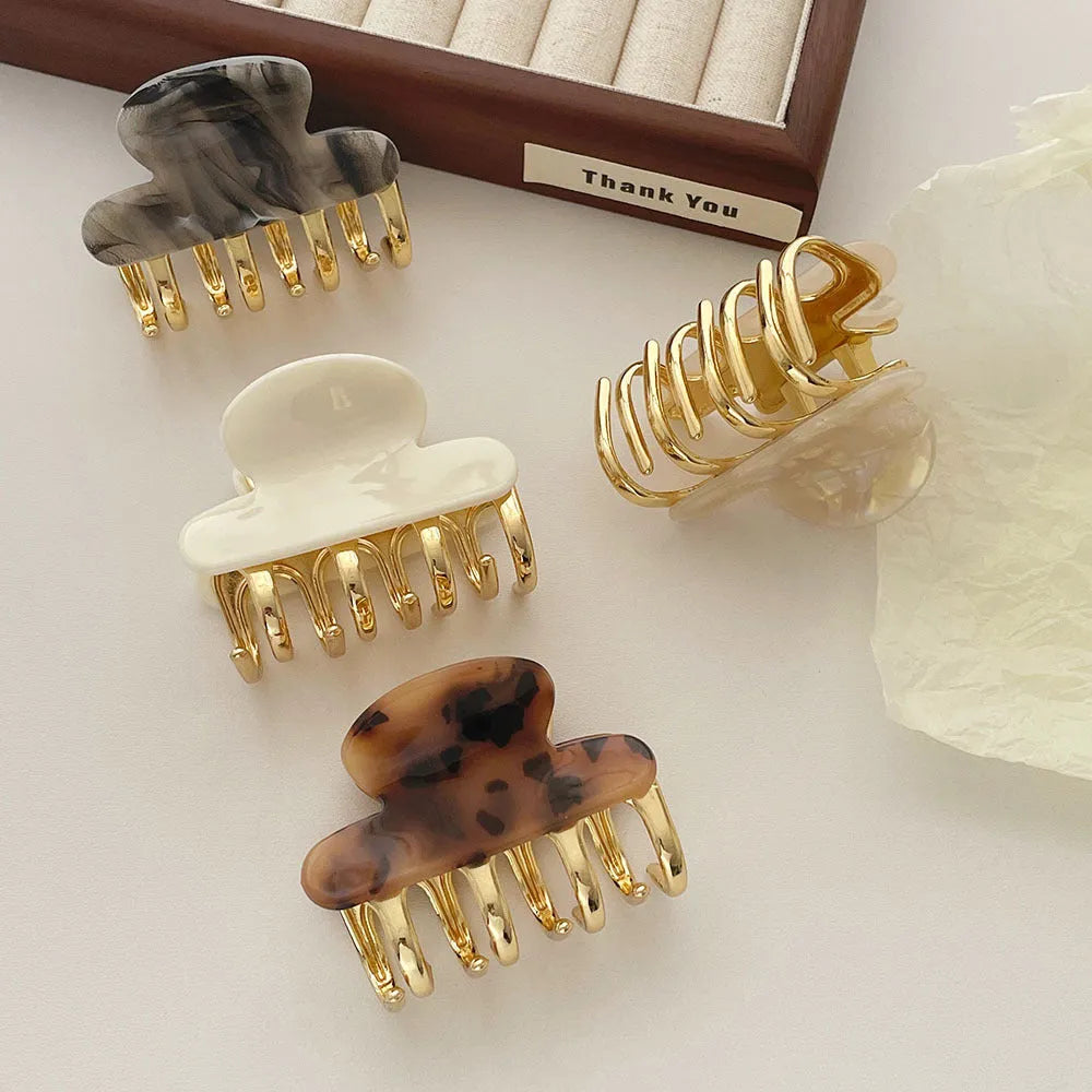 Set of four retro acetate hair barrettes with metal grip in beige, white, dark, and leopard print designs