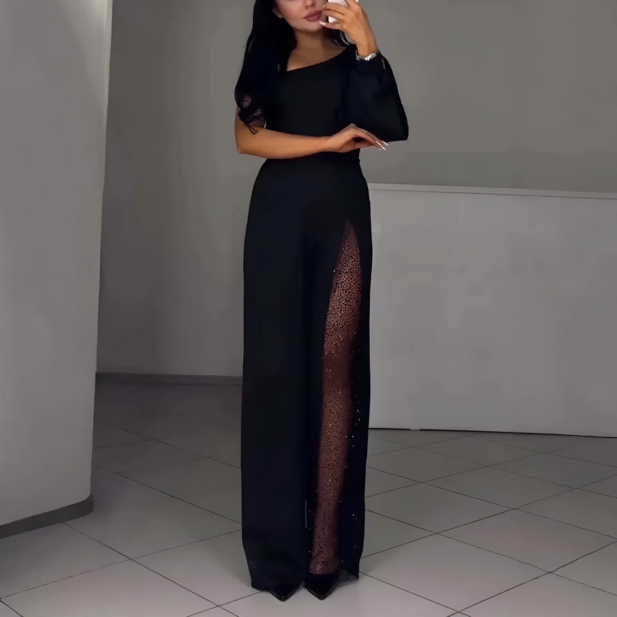 Black women's jumpsuit with one shoulder cut and high leg slit, made from polyester fabric.