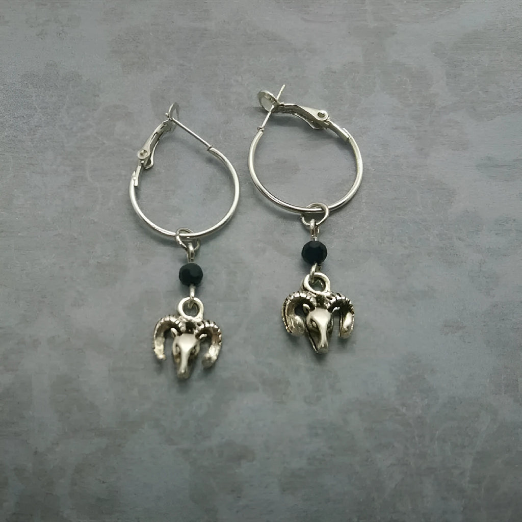 Silver-coloured round ring earrings for women featuring a raised Tibetan antelope design on an alloy metal hoop.