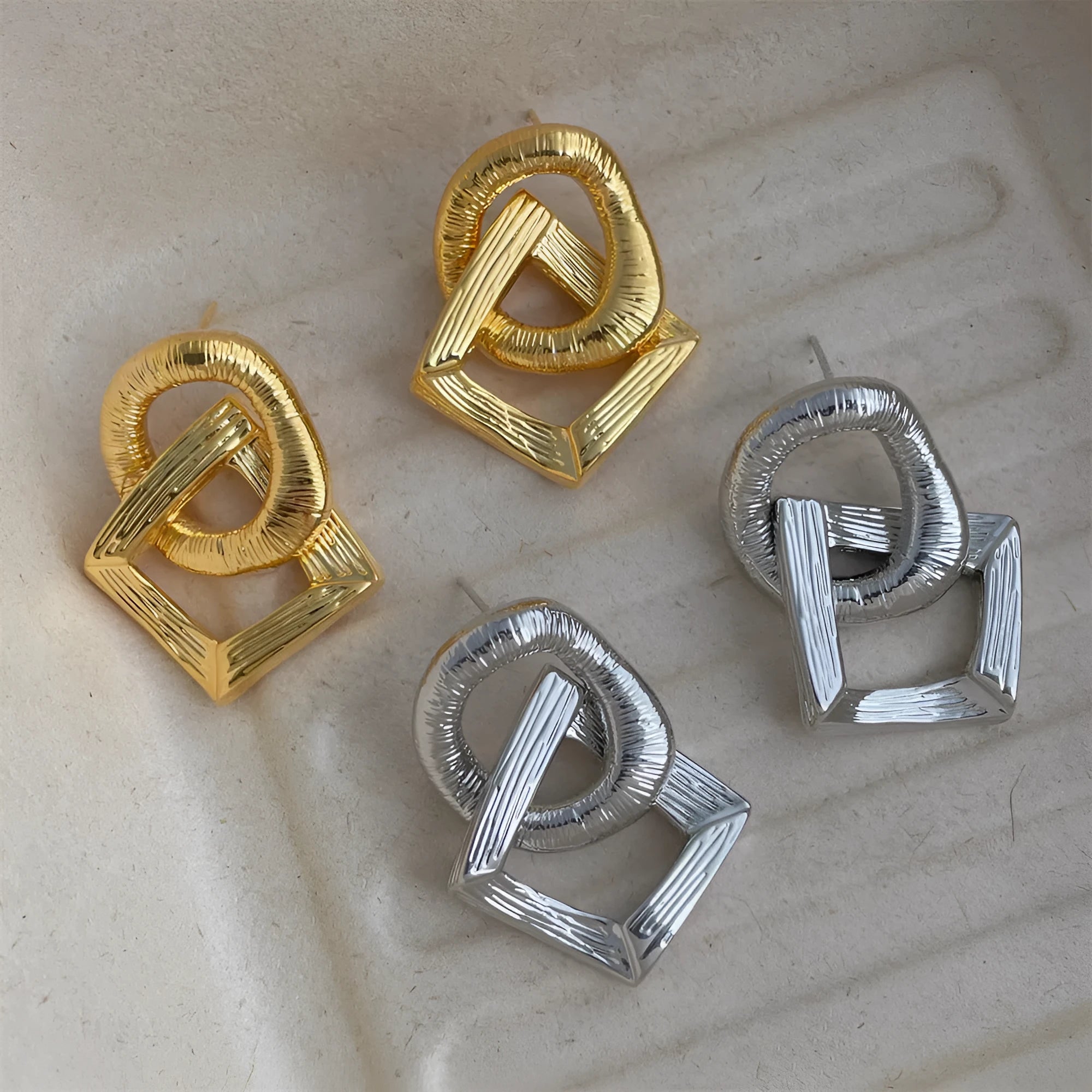 Retro geometric circle pendant earrings in gold or silver tone on a white background.
