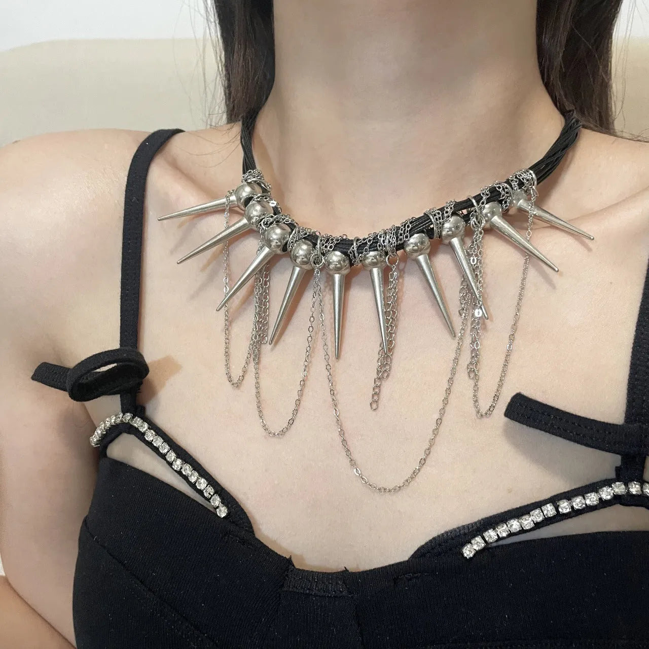 Women's casual leather necklace with round beads, a winding tassel, and decorative rivet details in an electroplated finish.