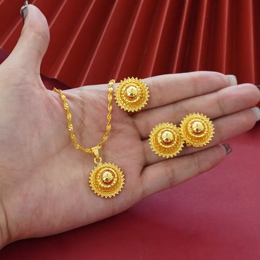 Gold-plated three-piece jewellery suit with landscape Middle East flower designs showing earrings, ring and pendant necklace