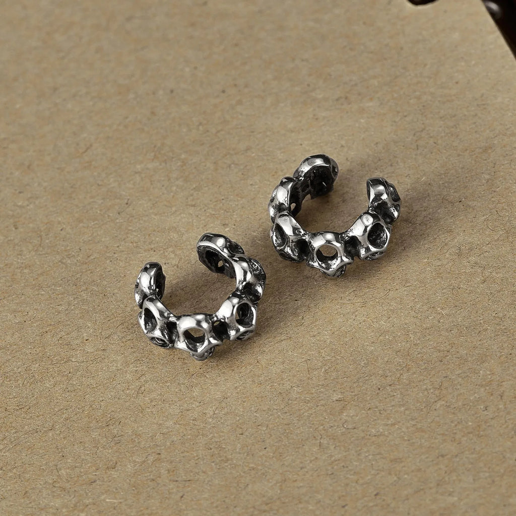 Stainless steel skull clip earrings with geometric hollow design and metallic finish