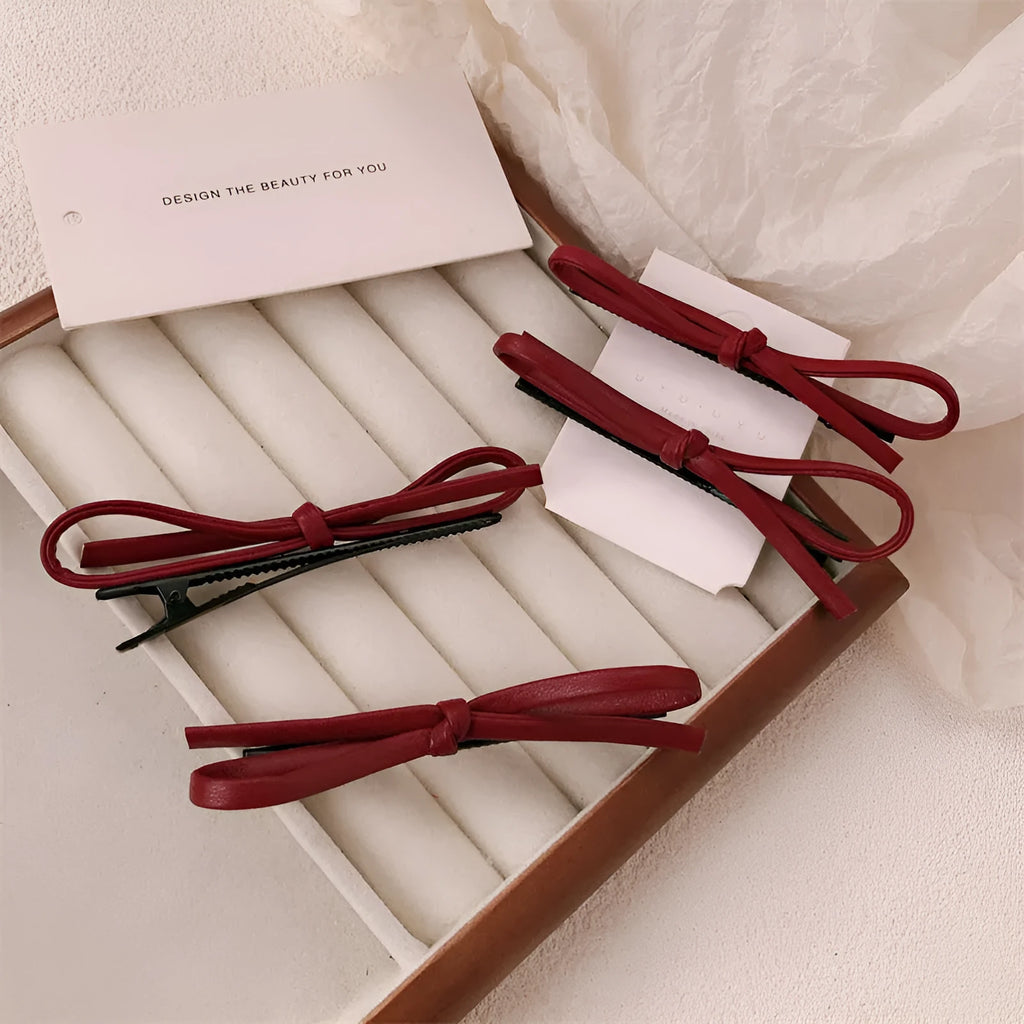 Wine red leather bow hair barrette on hair, showing single clip design