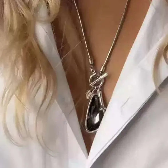 Long alloy sweater chain necklace with a geometric plaid pendant on a snake bones chain.