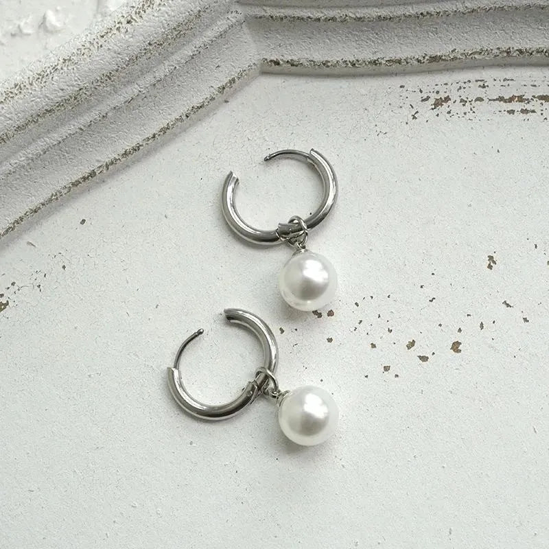 A pair of women's geometric alloy drop earrings with a round pearl centre and titanium steel post.