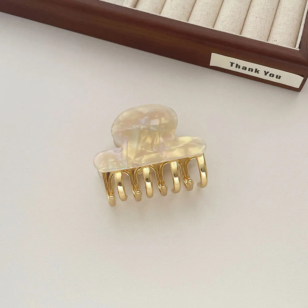 Set of four retro acetate hair barrettes with metal grip in beige, white, dark, and leopard print designs