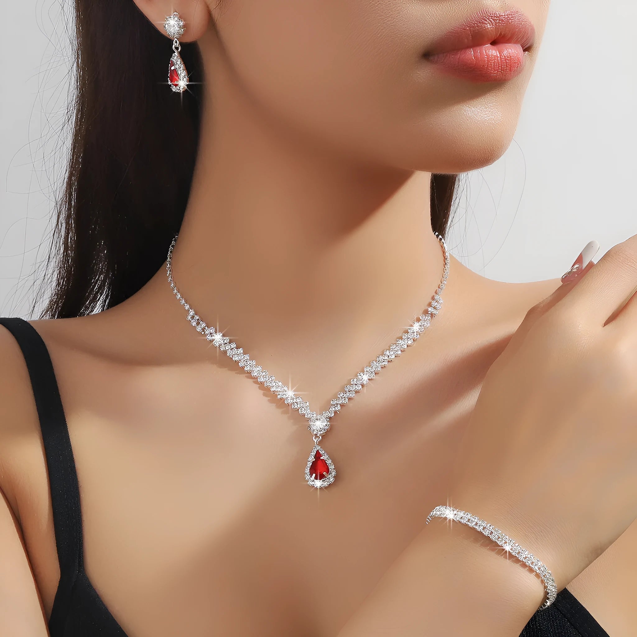 Women's blue claw chain necklace and drop rhinestone earrings from a matching jewellery set.