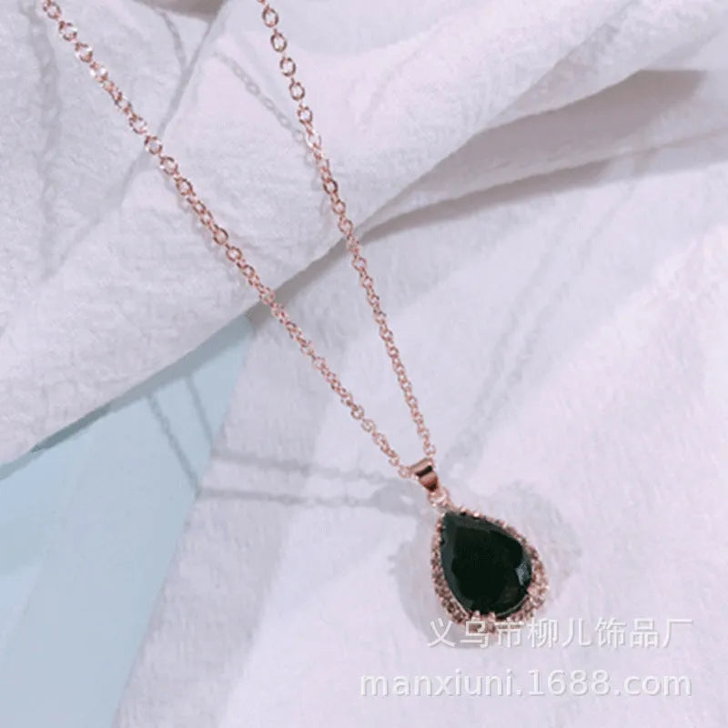 Pink water drop shaped rhinestone necklace with rose gold electroplated alloy pendant on white background
