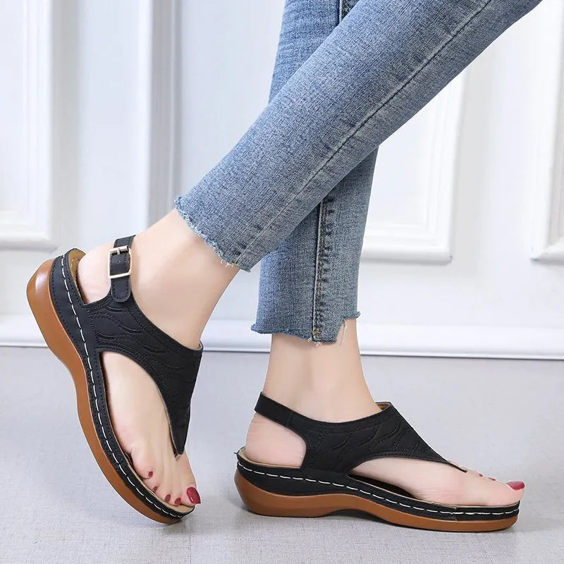 Women's casual wedge heel flip flop sandals with an adjustable buckle strap in black.