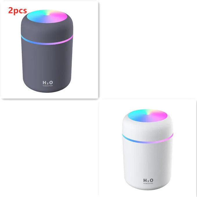 Pink USB mini humidifier with LED lights and water tank on desk