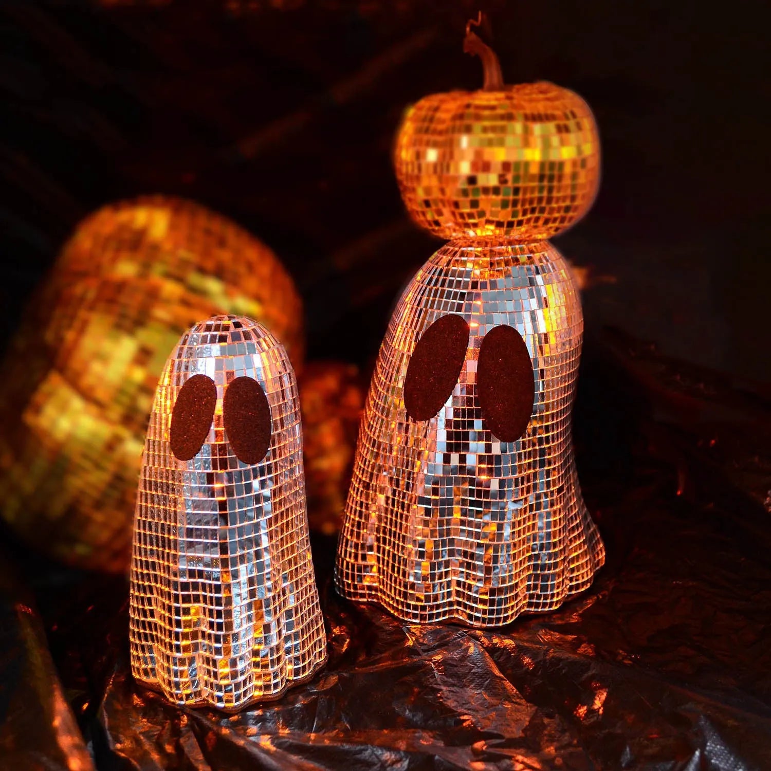 Silver Halloween ghost ornament with mosaic glass surface on wooden desk