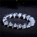 Women's white crystal ghost pyramid bracelet with Ruyi symbol on wrist, showing bead detail.