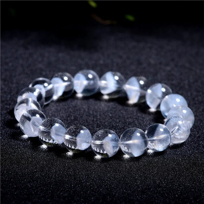 Women's white crystal ghost pyramid bracelet with Ruyi symbol on wrist, showing bead detail.